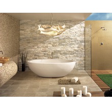 Lichte badkamer met vrijstaand bad, stenen muur en douche