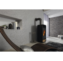 Woonkamer met houtkachel, relaxstoel en decoratieve wandbekleding