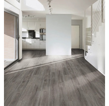 Lichte woonkamer met grijze houten vloer, trap en kitchenette