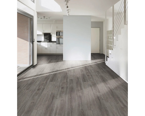 Lichte woonkamer met grijze houten vloer, trap en kitchenette