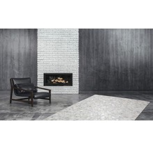 Woonkamer met fauteuil, open haard en tapijt
