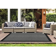 Terras met rotanmeubels en grijs vloerkleed