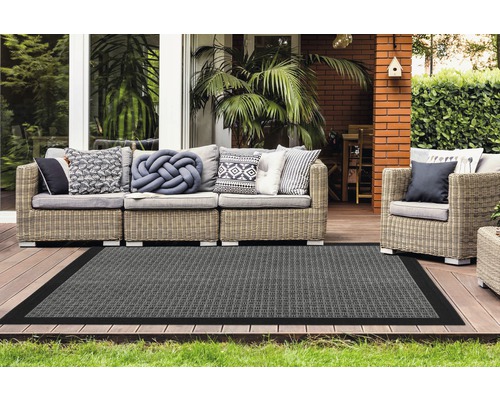 Terras met rotanmeubels en grijs vloerkleed