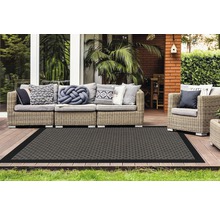Terras met rotan zitgroep en rechthoekig vloerkleed