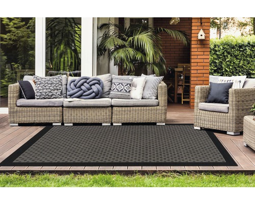 Terras met rotan zitgroep en rechthoekig vloerkleed