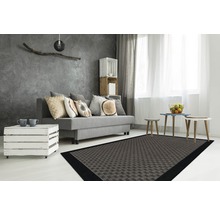 Moderne woonkamer met bank, houten kist als tafel en een vloerkleed met motief