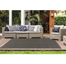 Terras met rotan bankstel en donker tapijt