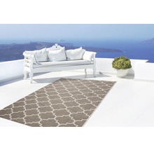 Terras met buitenkleed, bank en potplant met uitzicht op zee