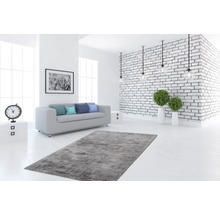 Lichte woonkamer met bank, vloerkleed en bakstenen muur