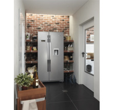 Keuken met side-by-side koelkast, planken, bakstenen muur en zwarte tegelvloer