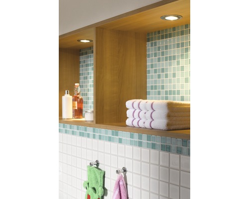 Badkamerwand met planken, handdoeken en tegels