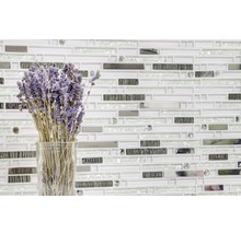 Muur met mozaïektegels met glazen vaas en lavendelbloemen