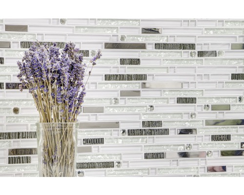 Muur met mozaïektegels met glazen vaas en lavendelbloemen
