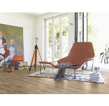 Lichte kamer met houten vloer, stoel, lamp en schilderij