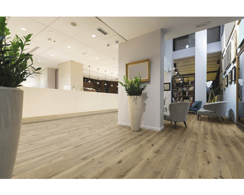 Lichte ontvangstruimte met houten vloer, planten en zitplaatsen.