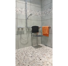 Badkamer met douche, douchestoel en handdoekhouder