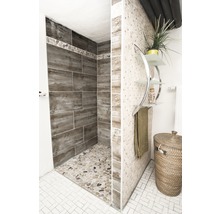 Badkamer met douche, tegels en decoratieve items voor een lichte en vriendelijke sfeer.
