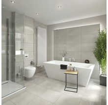 Lichte badkamer met ligbad, douche, toilet en radiator