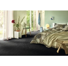 Slaapkamer met donkere vloerbedekking, bed en raam