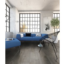 Lichte ruimte met bank, fauteuil en groot raam met roeden
