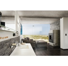 Modern interieur met wastafel, open haard en zithoek met uitzicht op zee