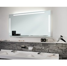 Badkamer met verlichte spiegel en dubbele wastafel.