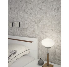 Slaapkamer met mozaïekmuur, bedlamp en wit bed