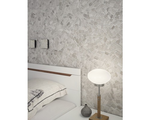 Slaapkamer met mozaïekmuur, bedlamp en wit bed