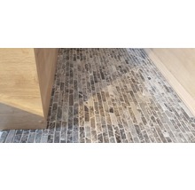 Detailopname van een vloer met mozaïektegels en een houten kast