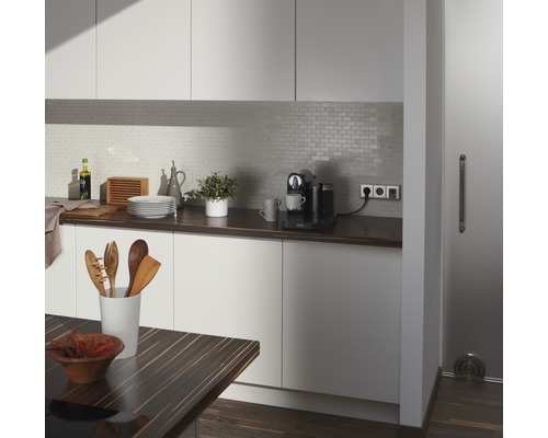 Lichte keuken met werkblad, keukengerei, koffiezetapparaat en tegelachterwand