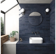 Badkamer met blauwe tegels, opzetwastafel, spiegel en wandlampen