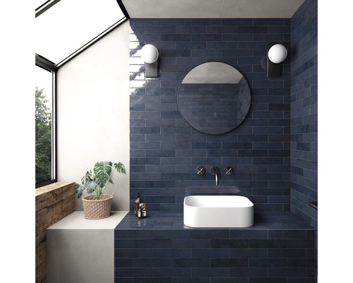 Badkamer met blauwe tegels, opzetwastafel, spiegel en wandlampen