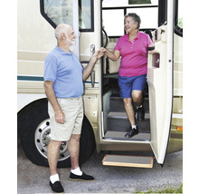Een echtpaar stapt uit een camper met een uitschuifbare opstap.