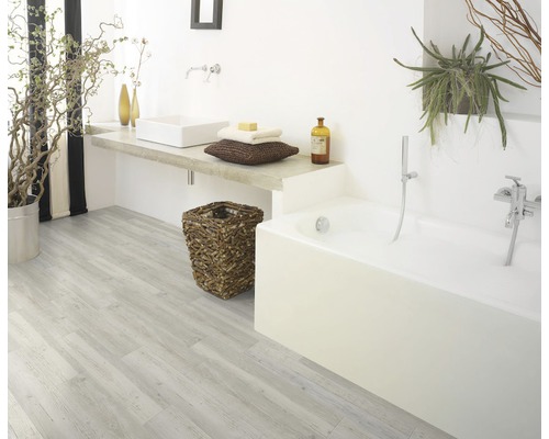 Badkamer met bad, wastafel, houten vloer en planten