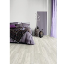 Slaapkamer met lichte houten vloer, bed, nachtkastje en decoraties.