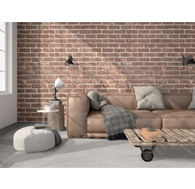 Woonkamer met leren bank, bakstenen muur en houten tafel