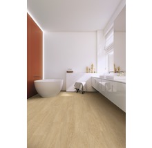 Moderne badkamer met vrijstaand bad, wastafel en lichte houten vloer.