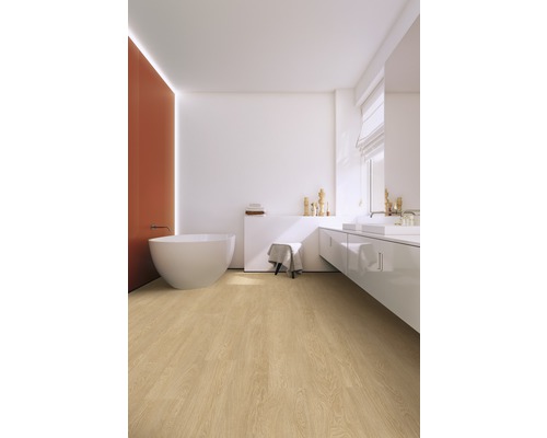 Moderne badkamer met vrijstaand bad, wastafel en lichte houten vloer.