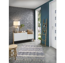 Woonkamer met stenen muur, dressoir, lamp, vloerkleed en houten ladder