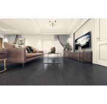 Lichte woonkamer met bank, tafel en donkere houten vloer.