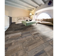 Woonkamer met houten vloer in plankmotief met opschriften, bank en tafel.