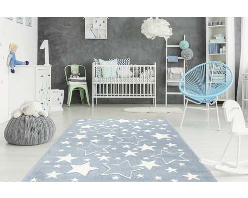 Kinderkamer met blauw tapijt met sterrenpatroon, ledikant en speelgoed