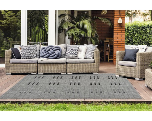 Grijze buitentapijt met geometrisch patroon op een terras met tuinmeubilair