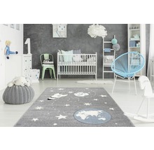 Kinderkamer met tapijt, babybed, fauteuil en speelgoed