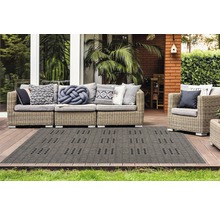 Terras met rotan bank, fauteuil en een grijs buitentapijt met motief.