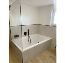 Badkamer met ligbad, douchewand en tegels