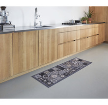 Keukenscène met houten keukenkasten en een grijs vloerkleed met een patroondesign