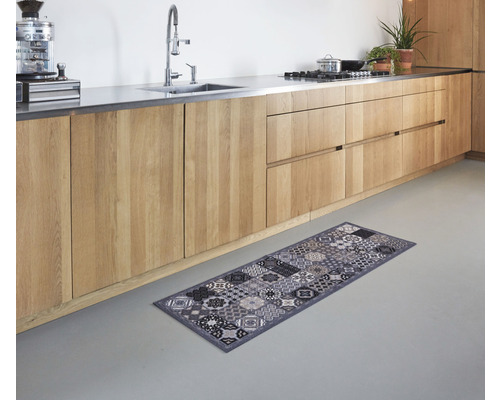 Keukenscène met houten keukenkasten en een grijs vloerkleed met een patroondesign