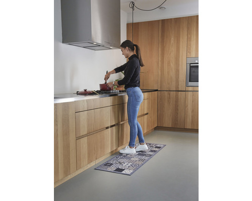 Vrouw kookt in een lichte keuken met een keukenloper