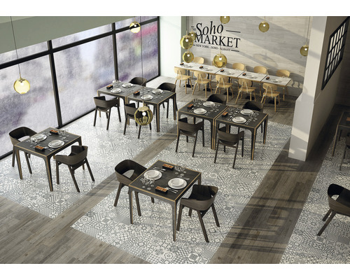 Interieurfoto van een restaurant met tafels, stoelen en vloertegels in een patroondesign.